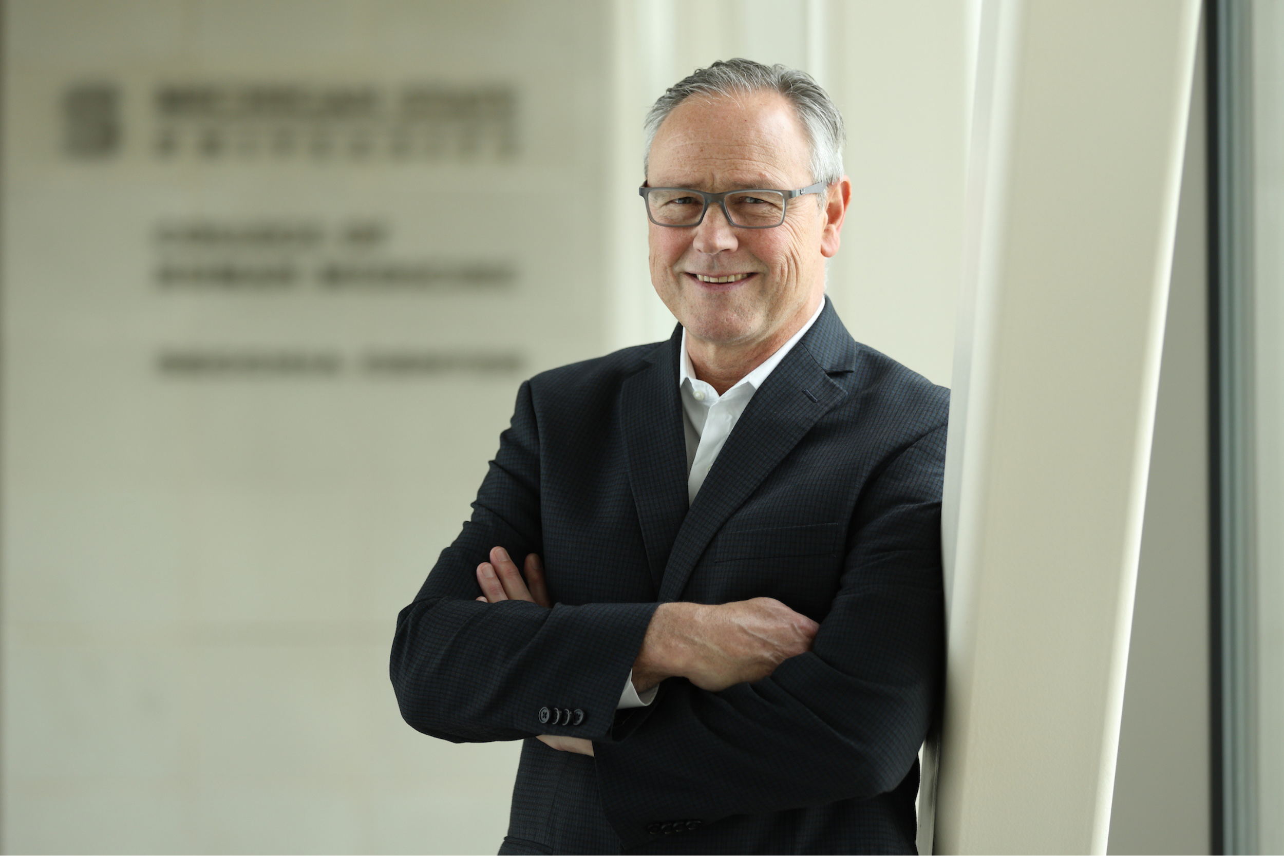 University Physician Michael Brown, MD ('82), MSc, leaning against a wall.